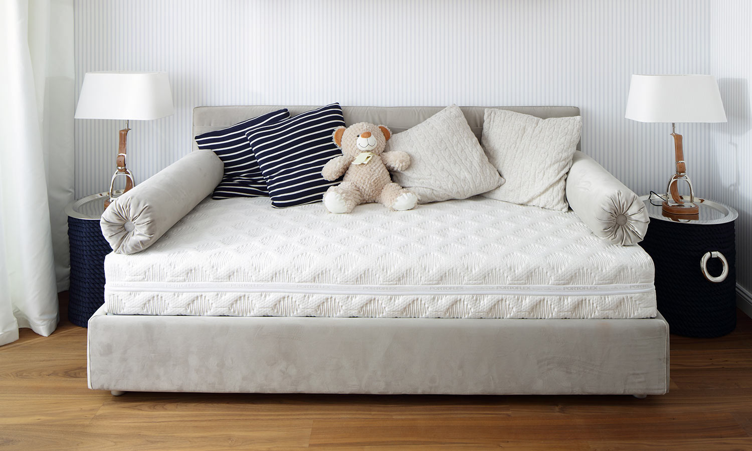 A day bed with pillows and a teddy bear on top