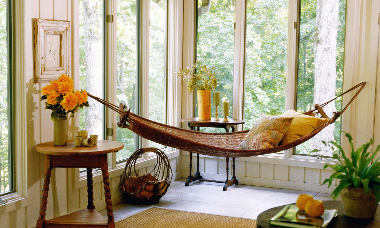 A slim hammock hangs next to a sunny window.