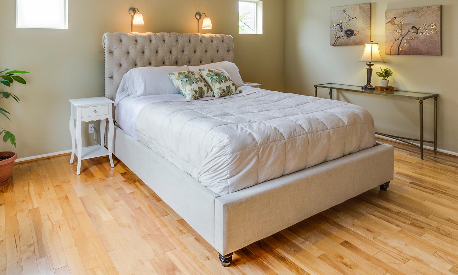 An upholstered bed with a built-in tufted headboard