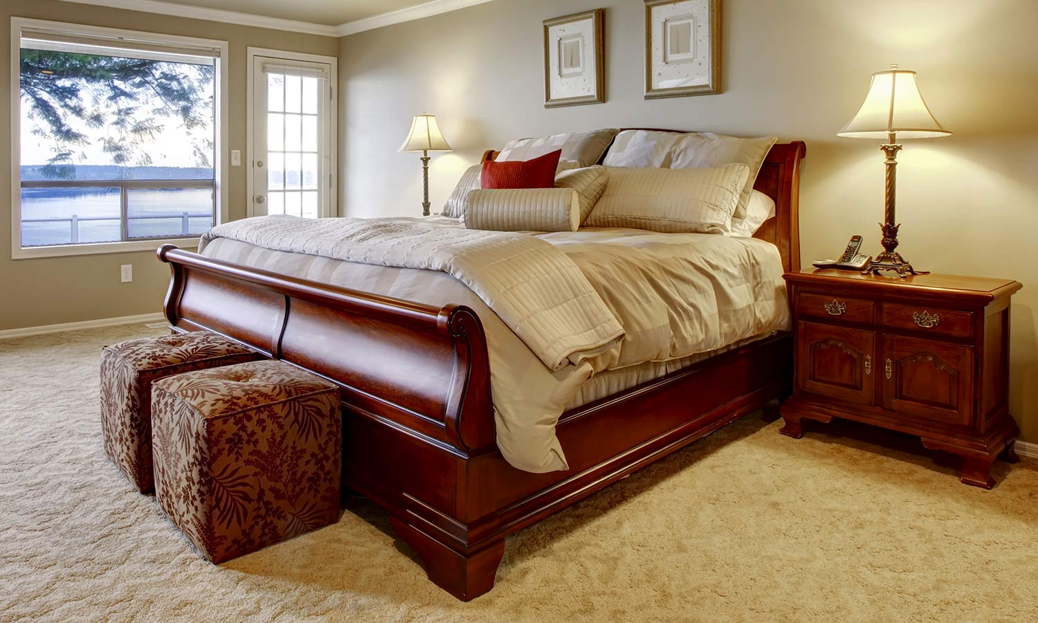 A traditional sleigh-style framed bed, with curving wood at the foot and head.