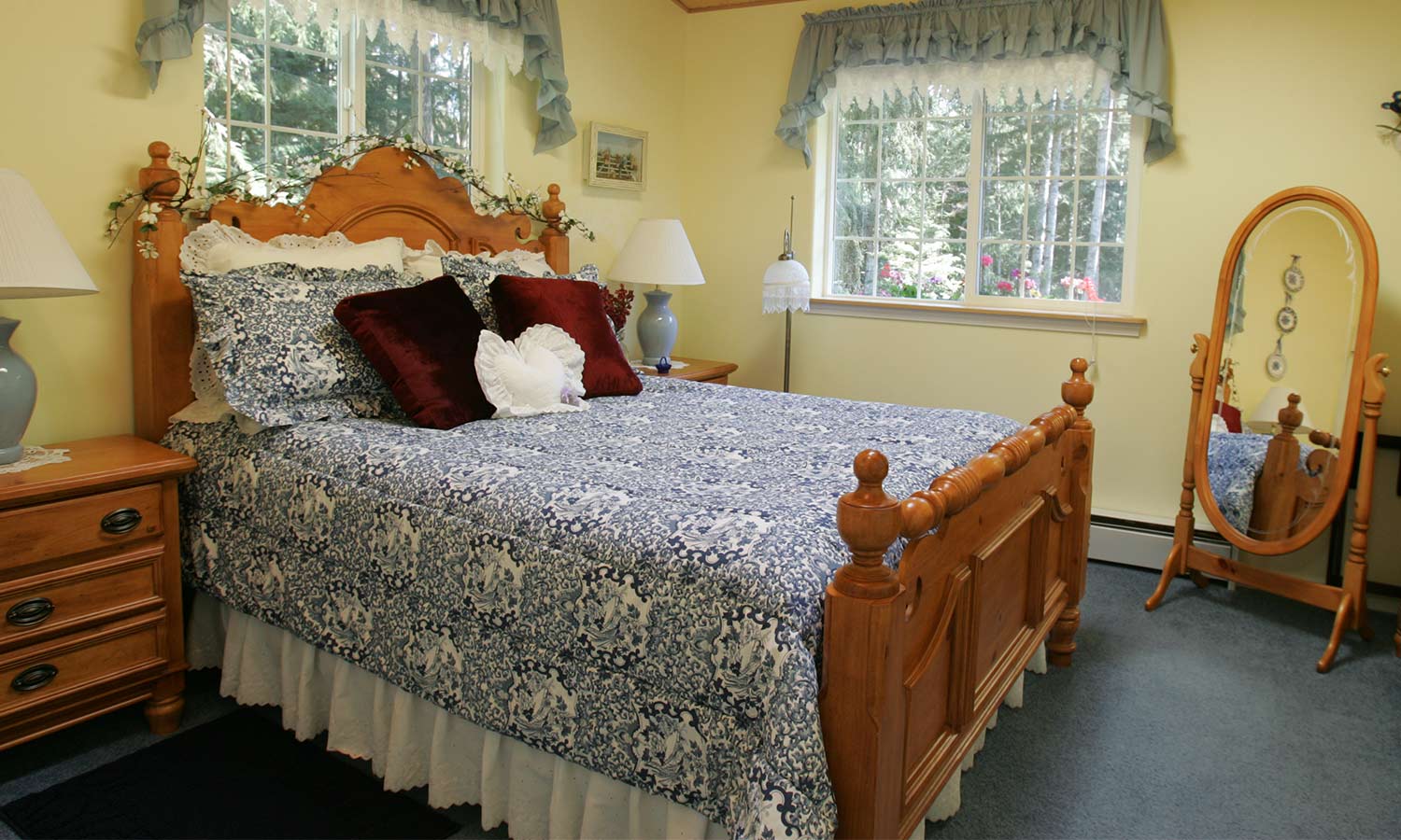 A wooden bed frame with and ornately-carved headboard and footer.