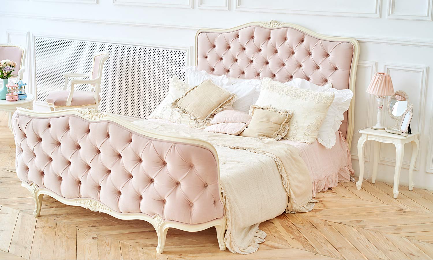 An ornate and bright bed fram tufted on the headboard and footer with thick pink fabric.