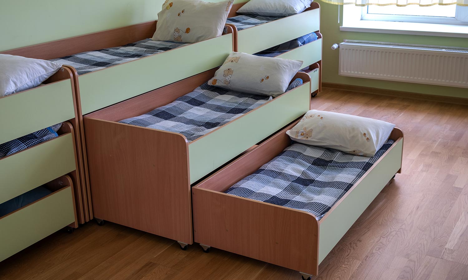 A stacked trundle bed that pulls out to reveal 3 beds in total