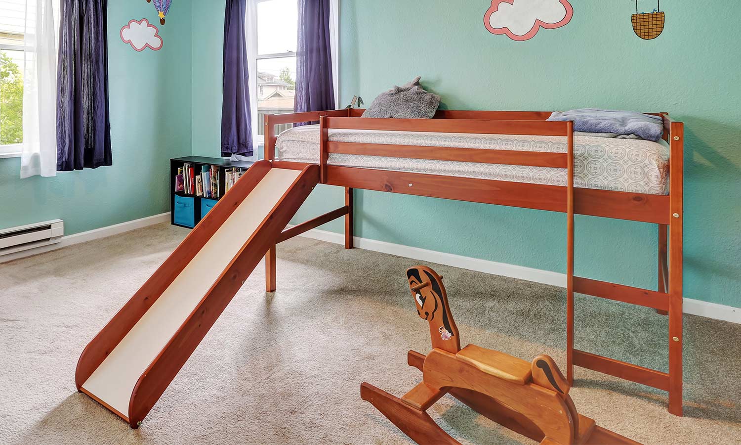 A bed lifted off the ground with a slide attached.