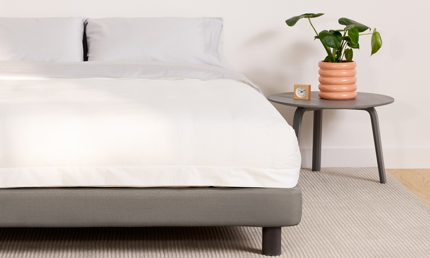 A simple upholstered bed frame with no headboard.