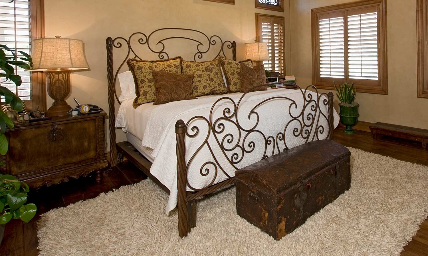 A metal bed frame with thin swirls woven throughout the headboard.