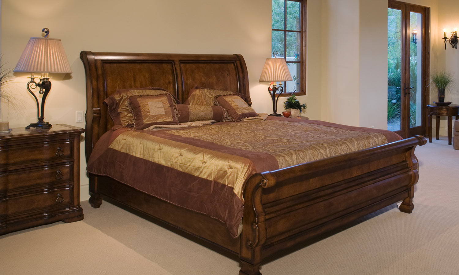 A wooden bedframe witht he headboard and footer curved outwards, resembling a sleigh.