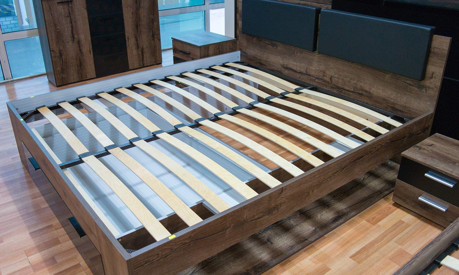 A bed frame where curved wooden slats act as a mattress base.