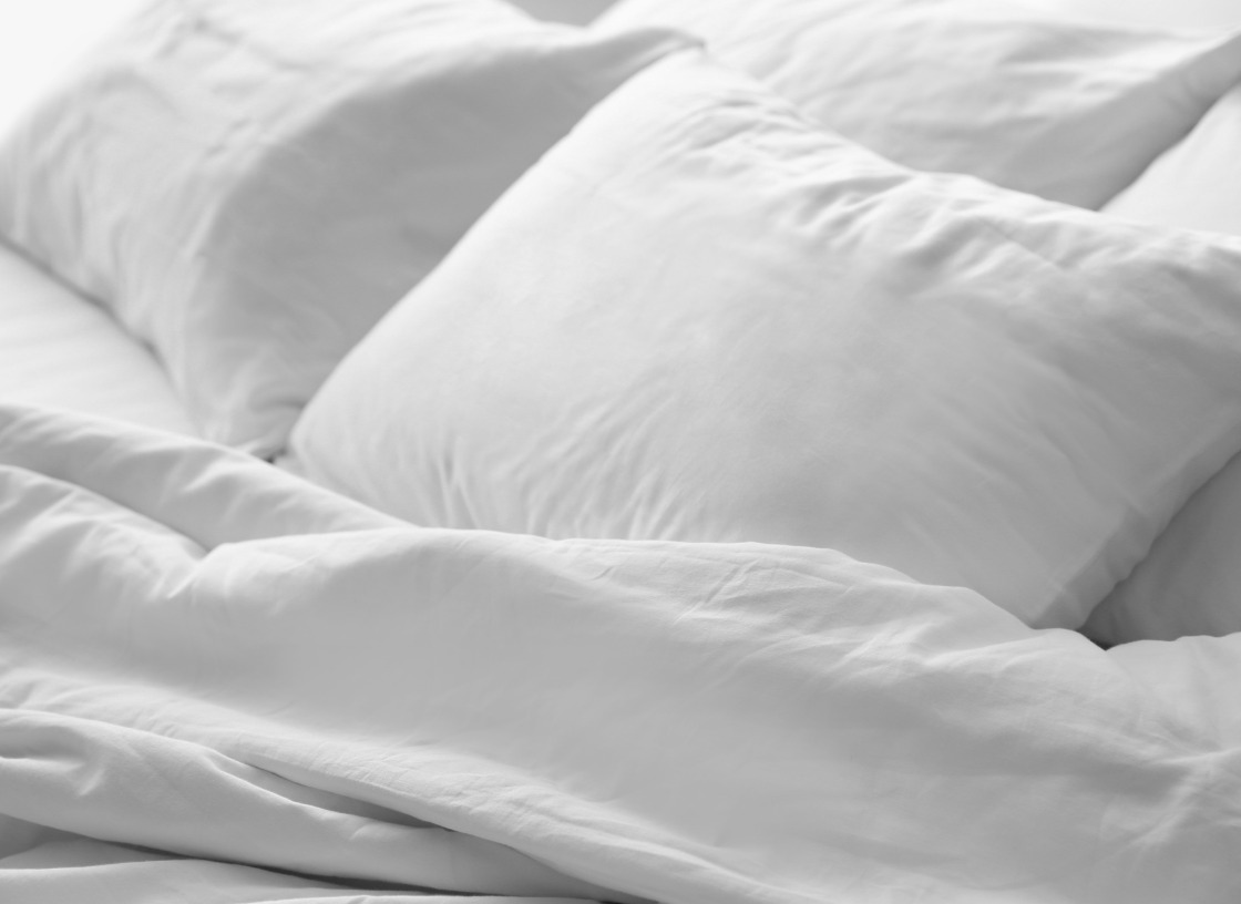 Two white pillows on all white bed