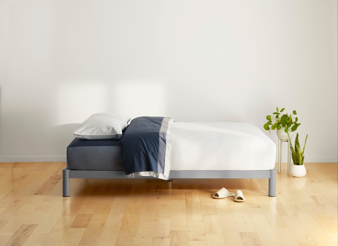 Grey platform bed and white-blue bedding on it